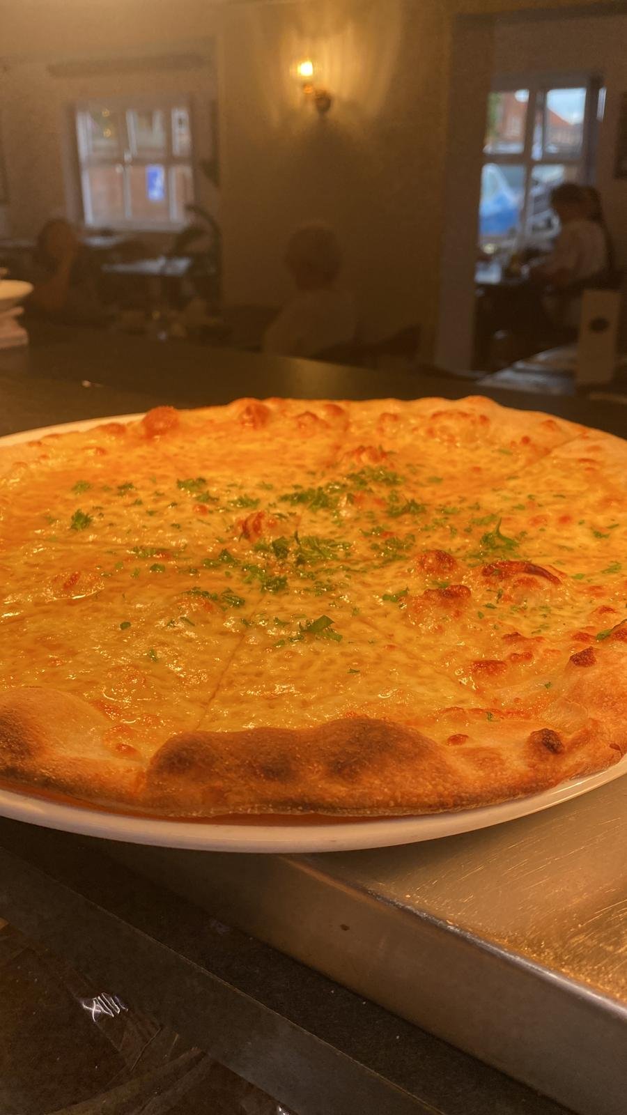 Wood-fired four cheese pizza finished with fresh parsley