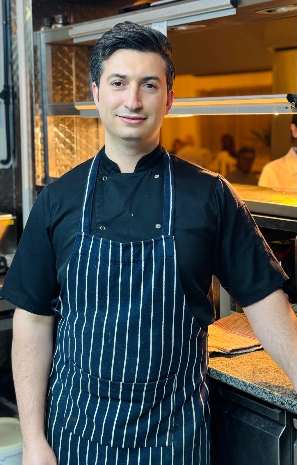 Chef Ridvan Palta holding a fresh tray of pistachio baklava
