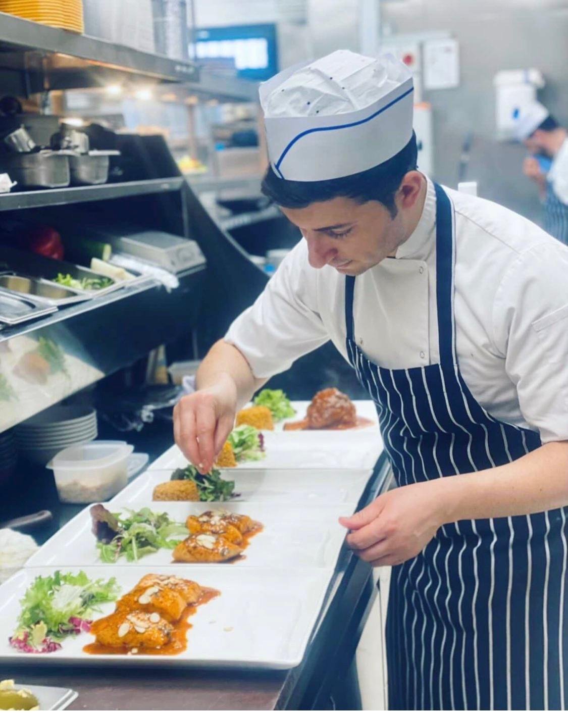 Chef Ridvan plating dishes on the pass